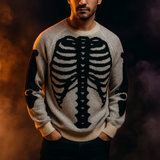 Beige knit pullover sweater with white skeleton ribcage and bone pattern, cozy Halloween-themed clothing.