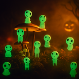 Glowing green cute ghost glow-in the dark light figures around mushrooms in a dark forest setting with a pumpkin in the background - Halloween Parker and Stone.