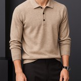 Men’s beige cashmere polo sweater with long sleeves, button-up placket, and classic collared design, styled with dark trousers.