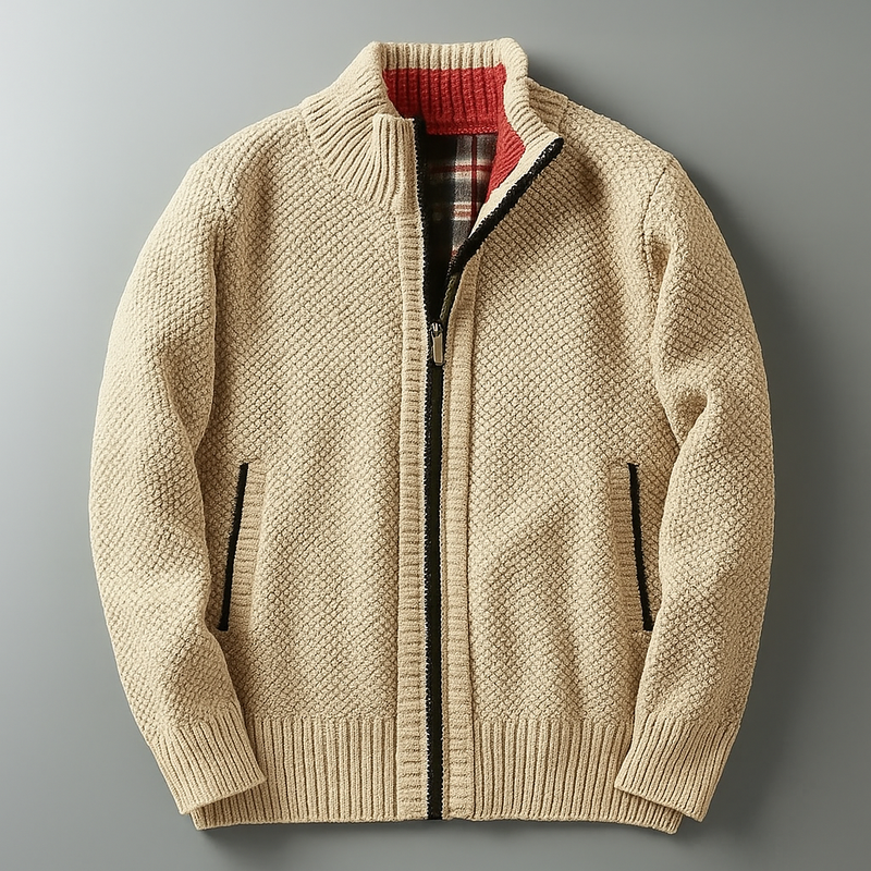 Beige knitted zip-up cardigan laid flat on grey surface, featuring ribbed cuffs, black zip lining, and red inner collar detail - luxury textured knitwear for men.