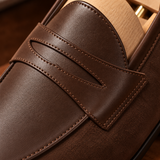 Close-up of Milano penny loafer strap detail in Chocolate leather