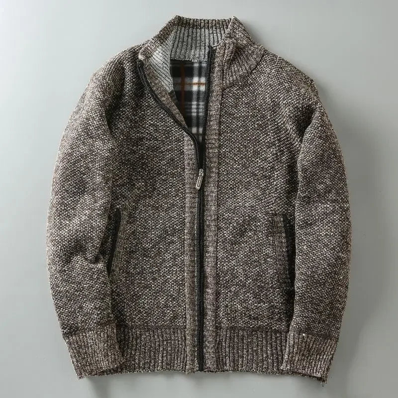 Brown knitted zip-up cardigan laid flat on grey surface, featuring ribbed cuffs, black zip lining, and light grey inner collar detail - luxury textured knitwear for men.