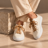 Woman wearing White Montaro leather sneakers with cream trousers